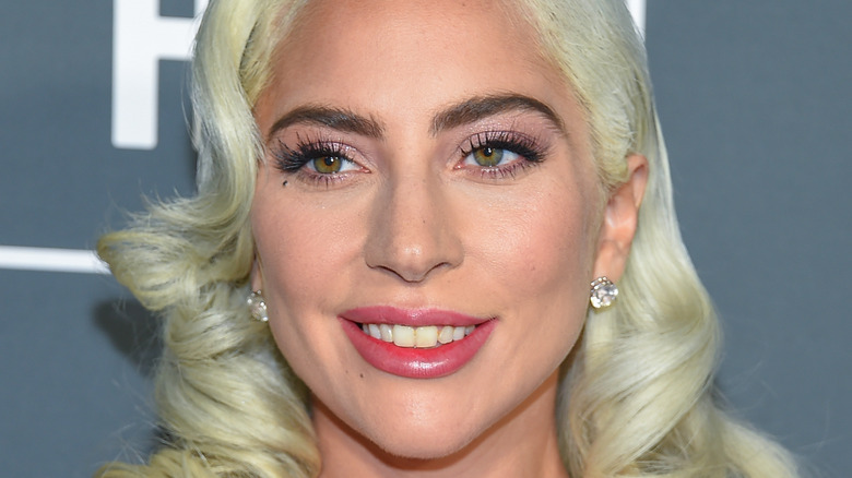 Lady Gaga smiling peroxide blonde bob pink lipstick