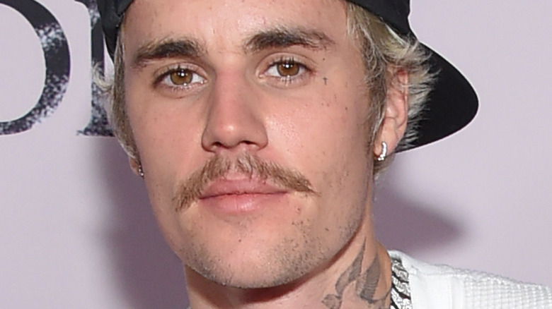 Justin Bieber with backwards hat and facial hair at red carpet