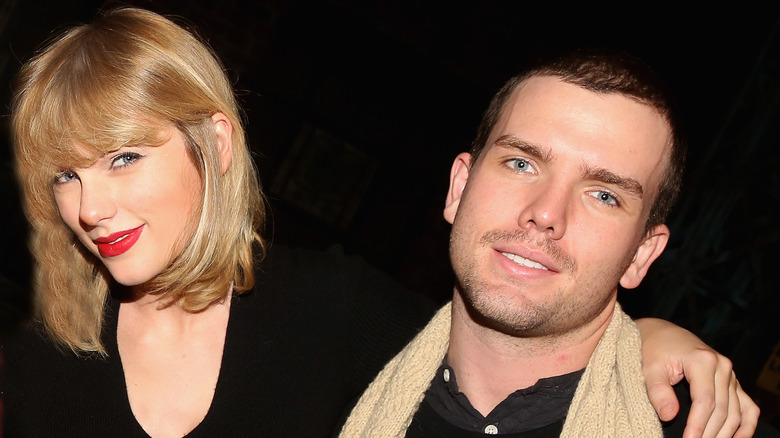 Taylor Swift smiling with her arm around Austin Swift