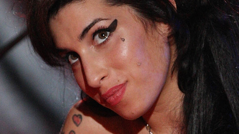 Amy Winehouse sits on stage