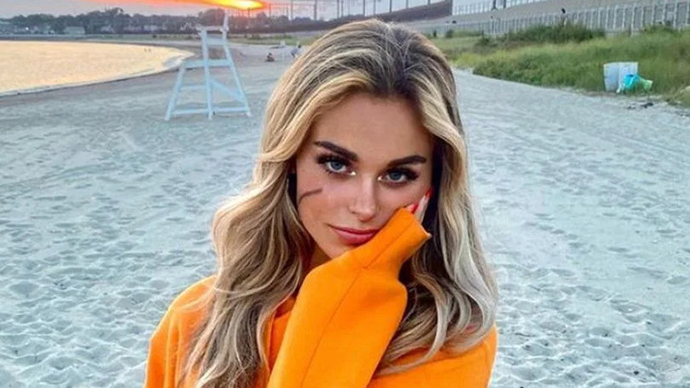Annie Bonelli posing in orange sweatshirt