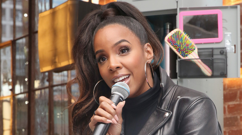 Kelly Rowland holds microphone