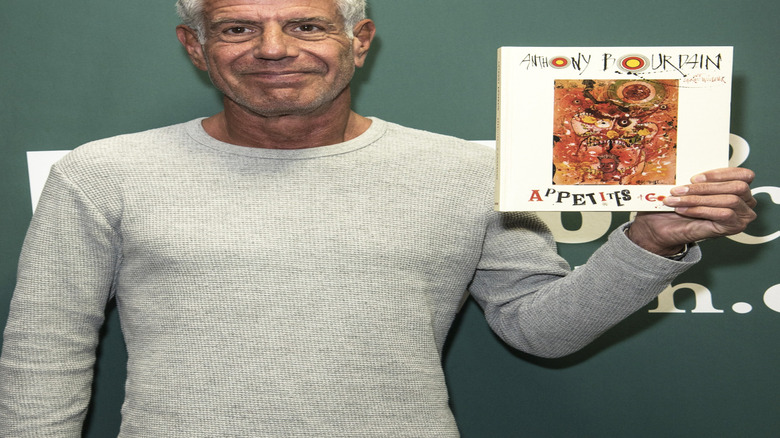 Anthony Bourdain shows off his book