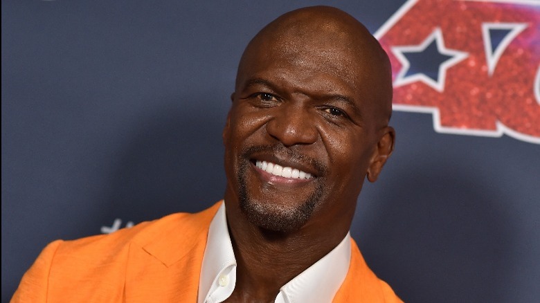 Terry Crews smiling in an orange suit