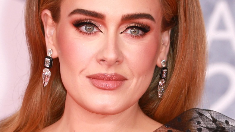 Adele smiling and wearing diamond earrings