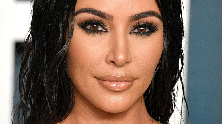 Kim Kardashian smiling and wearing heavy black eyeshadow