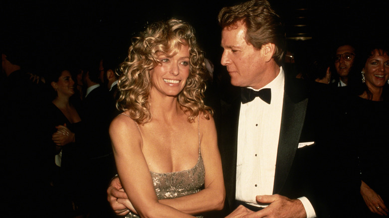 Farrah Fawcett wearing low-cut dress in 1989 next to Ryan O'Neal