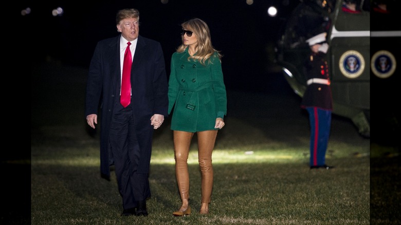 Melania Trump wearing skin-colored pants while walking hand in hand with President Trump at night