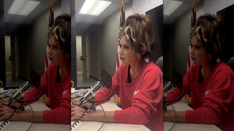 Kristi Noem speaking into microphone with her hair pulled up.