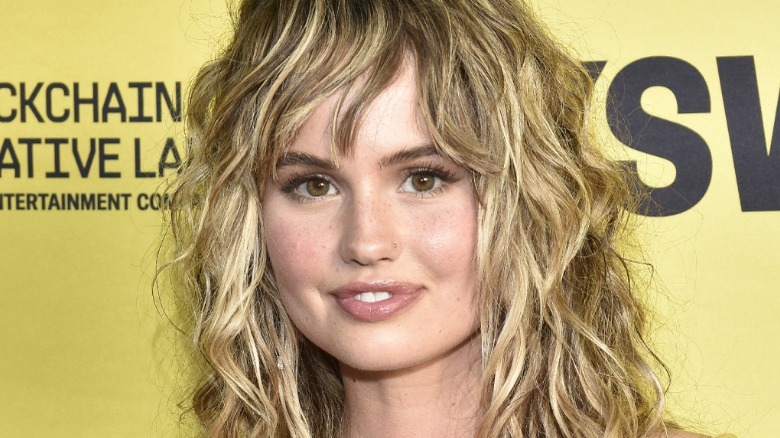 A closeup of Debby Ryan yellow background smiling