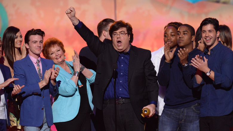 Dan Schneider accepting an award alongside former Nickelodeon stars