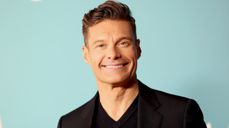 Ryan Seacrest in front of a blue backdrop