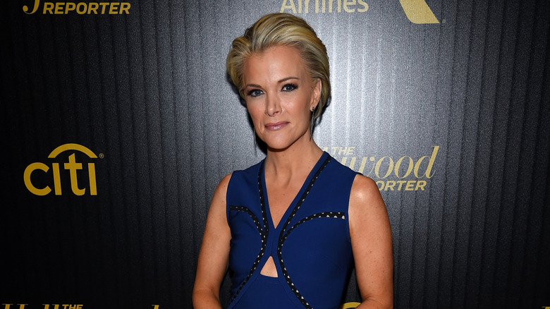 Megyn Kelly with her hair swept back in front of a dark background