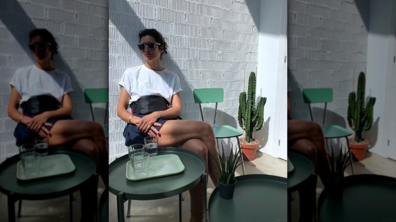 Elena Moussa sits at a table with legs crossed