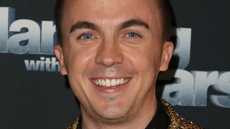 Frankie Muniz smiles in a mustard jacket