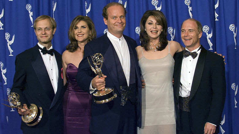 The Frasier cast smiling at the Emmys, with Kelsey Grammer and David Hyde Pierce holding awards.