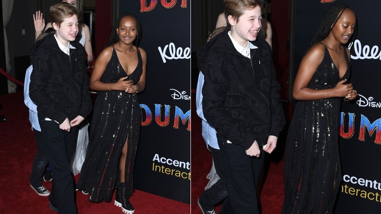 Zahara Jolie wearing a black sequined dress and walking at movie premiere with Shiloh Jolie.
