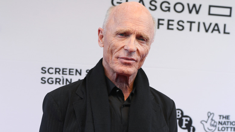 Ed Harris wearing a black suit