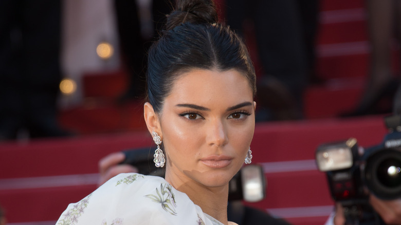 Kendall Jenner posing for a photo with a bun in her hair