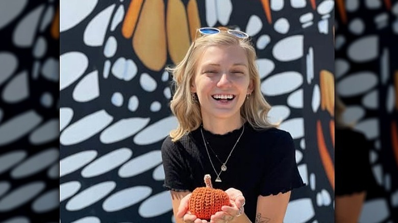 Gabby Petito holding a cloth pumpkin