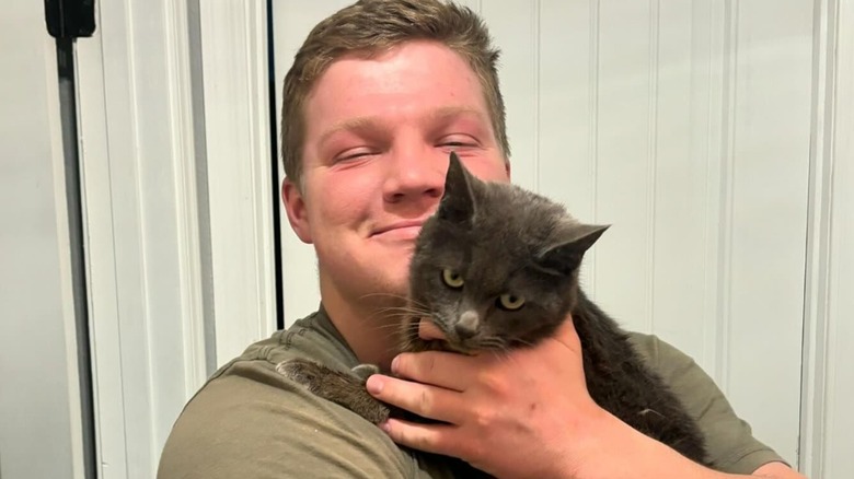 Garrison Brown smiling holding cat