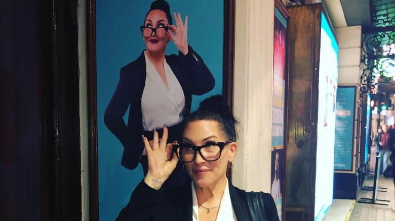 Michelle Visage posing in front of poster