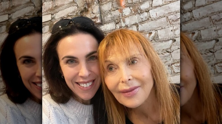 Tina Louise and Caprice Crane pose with their heads pressed together in 2024