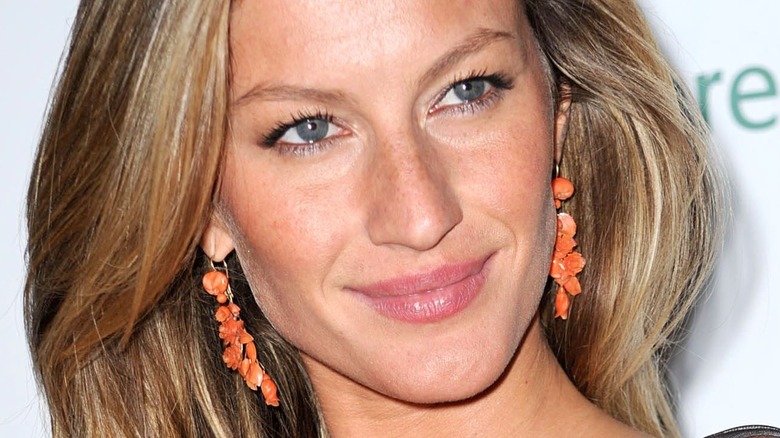 Gisele Bundchen orange earrings smiling