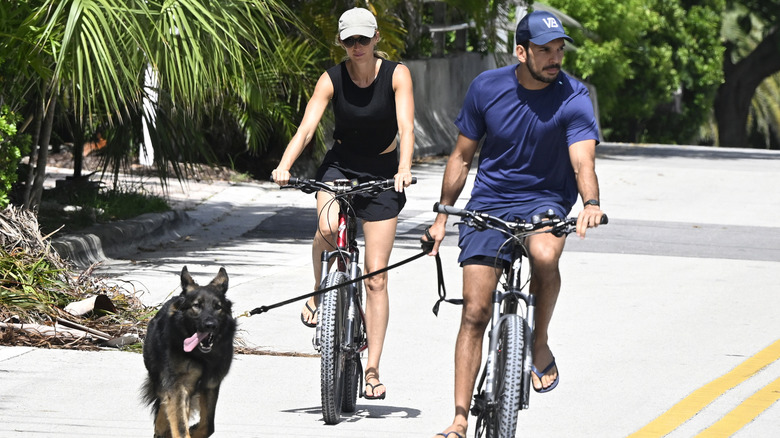 Gisele Bündchen and Joaquim Valente riding bikes with a dog