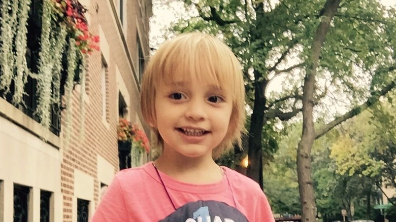 Duke Rancic wearing bangs and a mini bob flashes a toothy smile