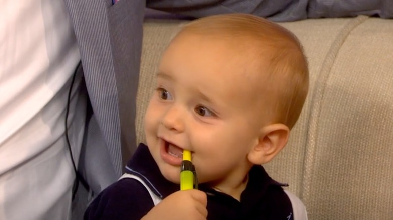 Baby Duke Rancic wears a happy expression while chewing on a highlighter