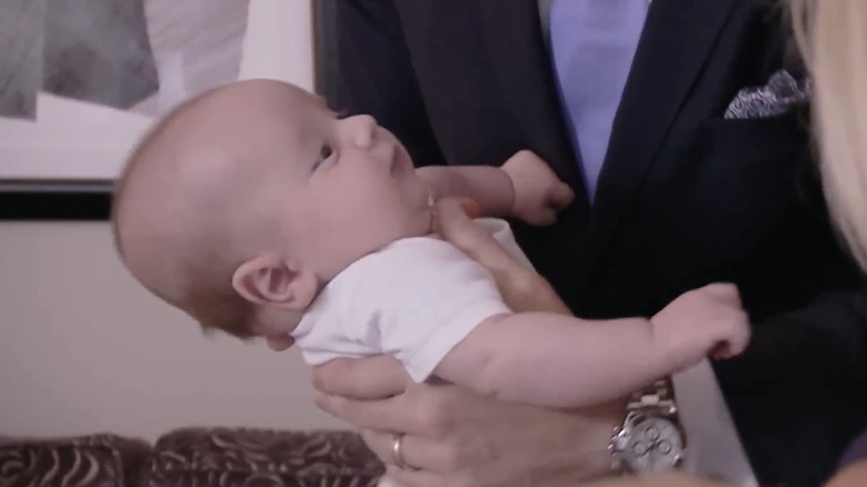 Baby Duke Rancic gazes at his parents while his father Bill Rancic holds him