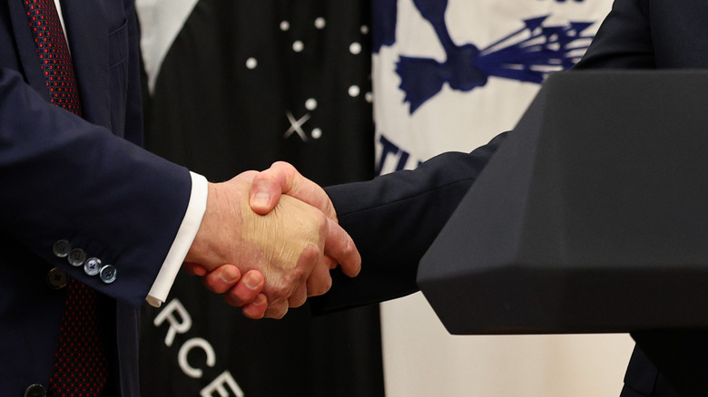 Donald Trump shakes hands with Tim Cook in August 2025