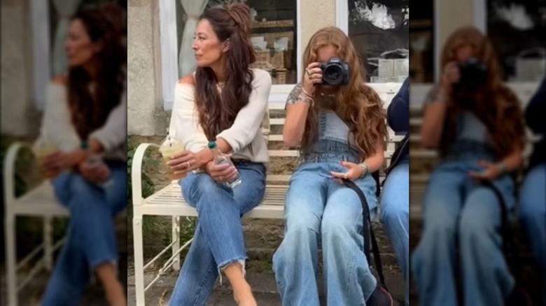 Ella Gaines taking a photo, sitting next to Joanna Gaines on a bench
