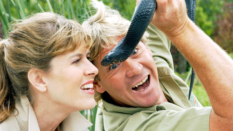 Terri Irwin and Steve Irwin holding a snake.