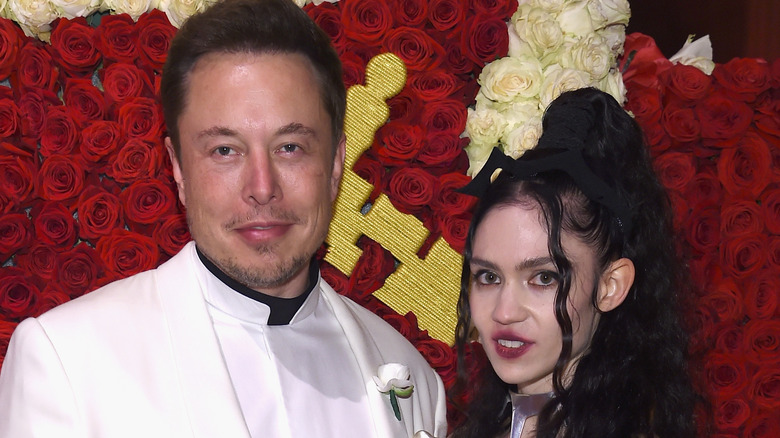Elon Musk and Grimes posing for a picture