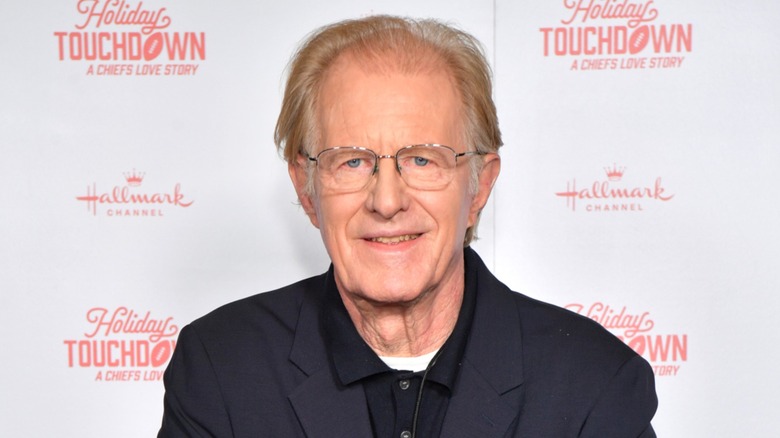 Ed Begley Jr sports an all-black outfit and smiles while looking directly at the camera.