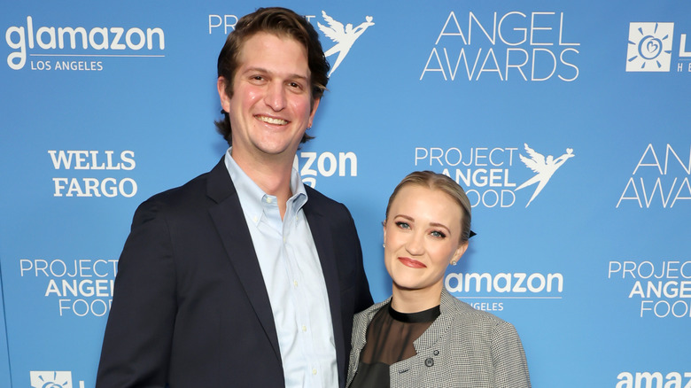 Emily Osment and Jack Anthony lean toward each other while smiling.