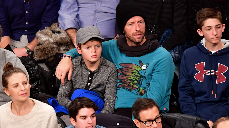 Chris Martin with his arm over his son