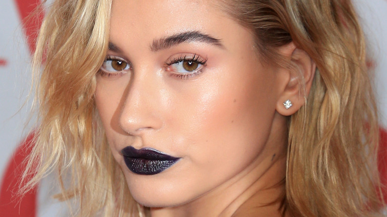 Hailey Bieber poses with black lipstick