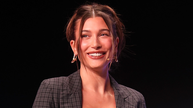 Hailey Bieber with dark hair, smiling