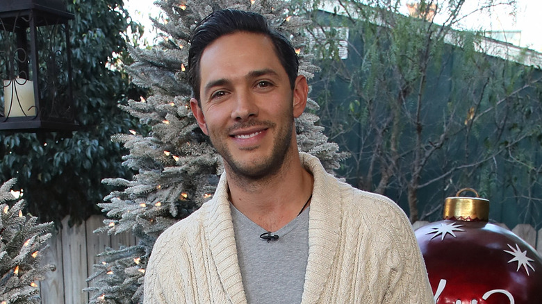 Michael Rady posing with Christmas trees