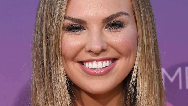 Hannah Brown with wide smile on red carpet 