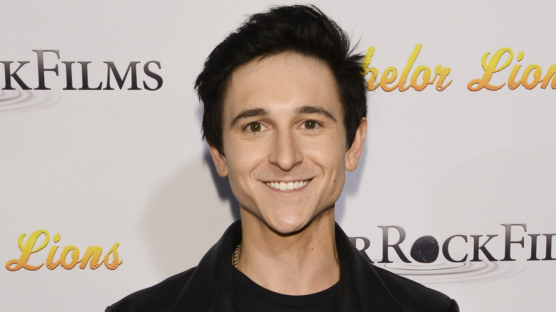 Mitchel Musso wearing black smiling