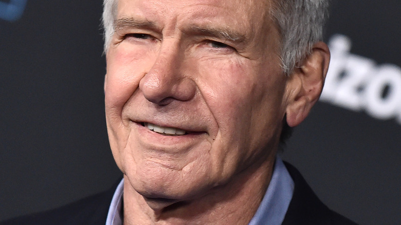 Harrison Ford smiles in a suit