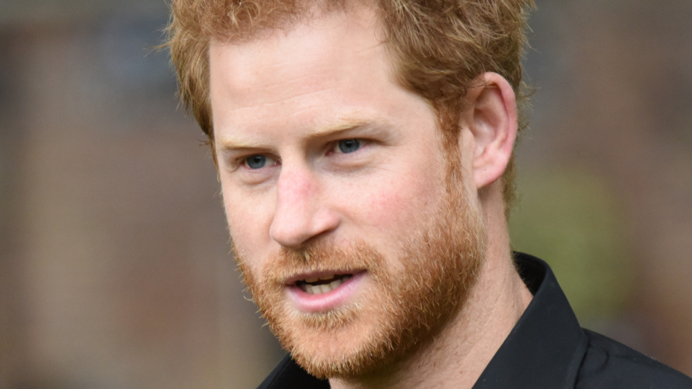 Prince Harry stands outside