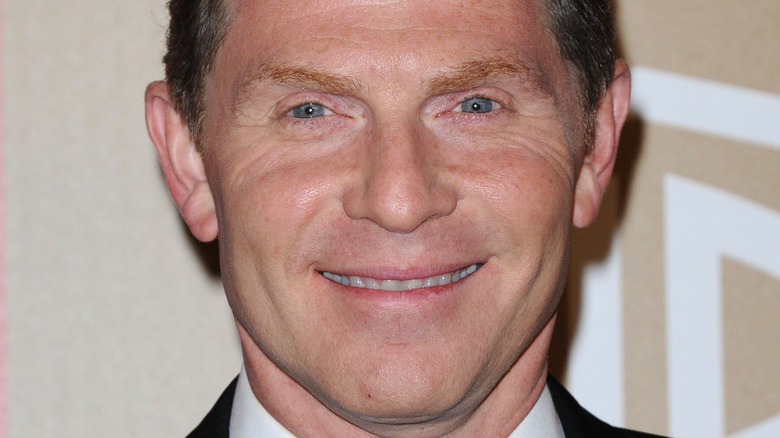 Bobby Flay smiles in a suit