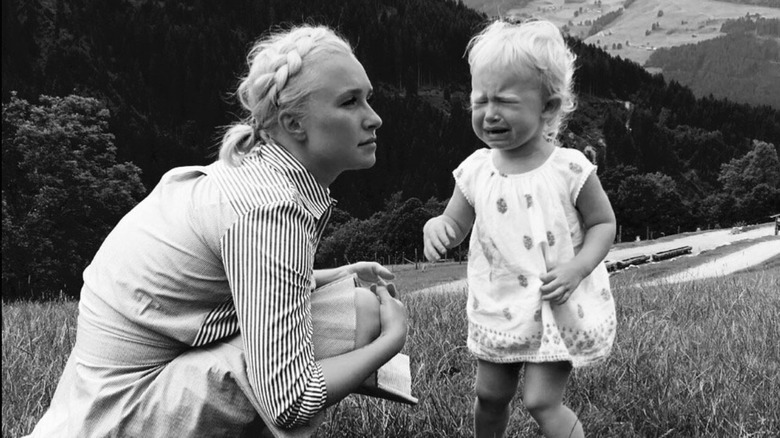 Hayden Panettiere crouches down next to her daughter who is crying