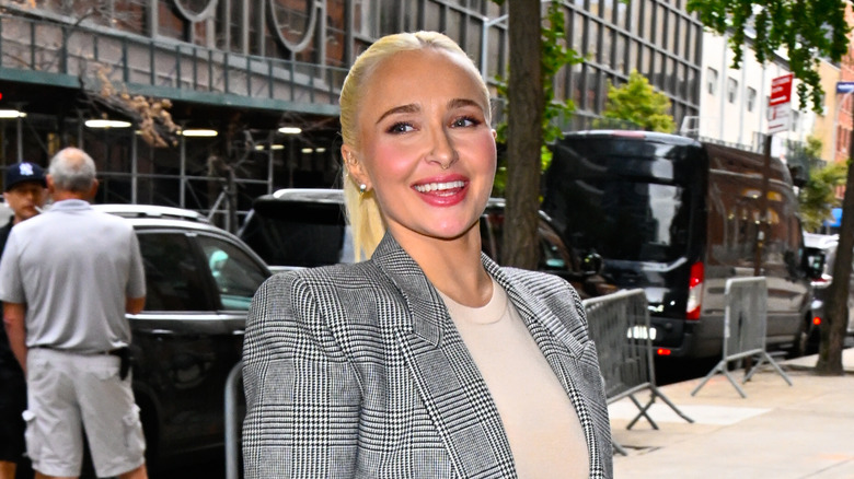 Hayden Panettiere wearing a blazer and walking into a book signing while smiling