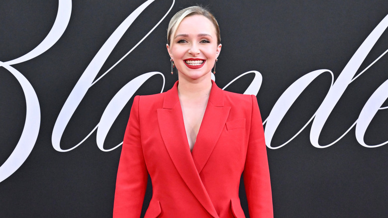 Hayden Panettiere smiling in a red blazer and matching lipstick at the premiere for "Blonde"